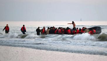 مهاجرون على قارب مطاطي يحاولون عبور المانش من فرنسا إلى بريطانيا، 11 تموز 2022 (AFP)