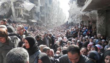 أهالي مخيم اليرموك جنوبي دمشق ينتظرون استلام مساعدات (الأونروا) يوم 31 كانون الثاني 2014 (رويترز)