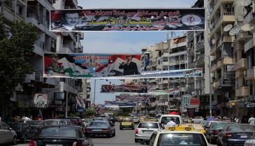 صور ولافتات مؤيدة لبشار الأسد في أحد شوارع اللاذقية (Getty)