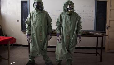متطوعون يرتدون الملابس الواقية من الكيماويات في حلب - أ ف ب