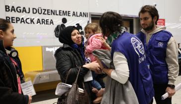 موظفون من وكالة الهجرة التابعة للأمم المتحدة يستقبلون عائلات سورية في مدريد، 4 آذار 2023 (IMO)