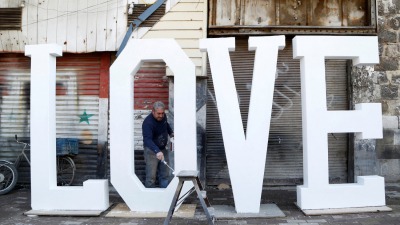 a-man-paints-letters-that-create-the-word-love-for-valentines-day-in-damascus.jpg