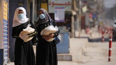 women_hold_stacks_of_bread_as_they_walk_along_an_empty_street_after_restrictions_are_imposed_to_prevent_the_spread_of_the_coronavirus_in_qamishli_syria_march_23_2020._reuters.jpg