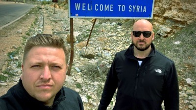 الصورة التي نشرها سايمون ويلسون عبر حسابه على تويتر والتي يظهر فيها واقفاً أمام الحدود السورية