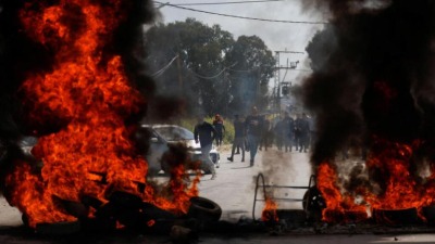 أهالي مخيم جنين يحاولون منع قوات الاحتلال الإسرائيلي من اتحام المخيم، 9 نيسان/أبريل 2022 (رويترز)