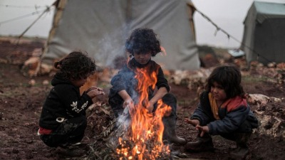 أطفال سوريون يتحوقون حول النار للتدفئة