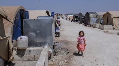 طفلة بالقرب من خزان مياه في إحدى المخيمات السورية شمال سوريا (الأناضول)