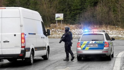 عنصر من الشرطة التشيكية يوقف إحدى السيارات المشتبه بها (رويترز)