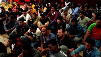 مهاجرون يجلسون في أحد طوابق السفينة بعدما تم إنقاذهم على يد منظمة الأذرع المفتوحة في 17 أيلول 2022