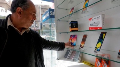 رجل في محل لبيع الموبايلات في سوريا (إنترنت)