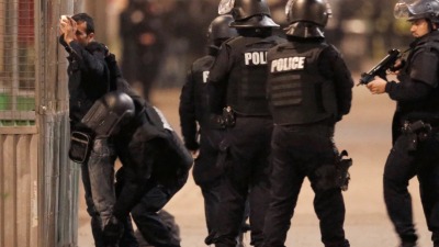 أثناء تفتيش الشرطة الفرنسية لأحد المدنيين في ضواحي باريس الشمالية (رويترز)