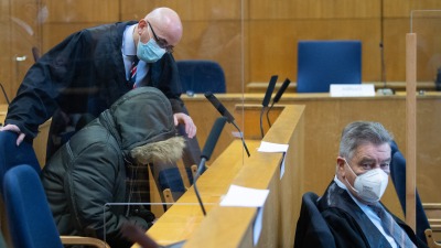 الطبيب السوري علاء موسى يتحدث إلى محاميه عند بدء محاكمته في فرانكفورت - 19 كانون الثاني 2022 (رويترز)