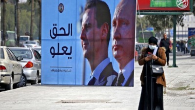 لافتة تمجّد رئيس النظام السوري بشار الأسد وحليفه الروسي فلاديمير بوتين مقدمة من صناعيي دمشق وريفها (AFP)