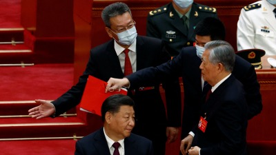 لحظة إخراج الرئيس الصيني السابق من مؤتمر الحزب الشيوعي في بكين (رويترز)