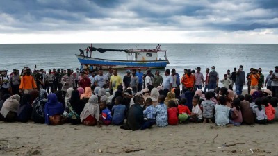 مجموعة من الروهينغيا هربت من ماينمار وهي تجلس على أحد شواطئ إندونيسيا