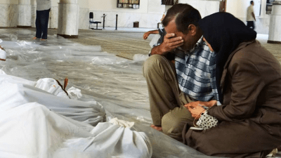 رجل وامرأة يبكيان أمام جثث بعد هجوم بالغاز السام شنته قوات النظام السوري في الغوطة