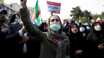 مظاهرة مناهضة للسلطة في طهران تتقدمها نساء إيرانيات (AFP)