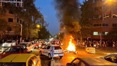 متظاهرون غاضبون يحرقون دراجة للشرطة في طهران عقب مقتل مهسا أميني (رويترز)