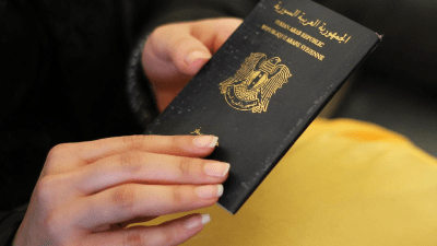 فتاة تحمل جواز سفر سوري
