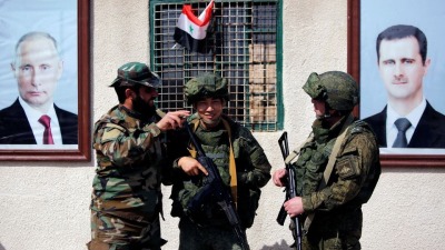 جنديان روسيان إلى جانب عنصر من قوات النظام عند نقطة تفتيش بالقرب من مخيم الوافدين في دمشق - 2 آذار 2018 (رويترز)