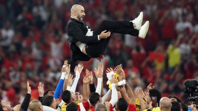 المنتخب المغربي يحتفل برمي المدرب وليد الركراكي في الهواء بعد الفوز على كندا (رويترز)
