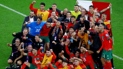لاعبو المغرب والجهاز الفني والإداري للمنتخب يقفون لالتقاط صورة بعد هزيمة البرتغال وتقدمهم إلى نصف نهائي المونديال - رويترز