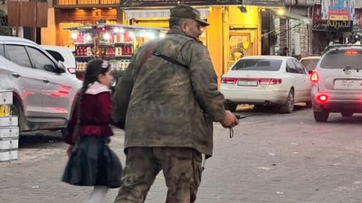 الملازم أول أحمد الصالح خلال مساعدته طلفة لعبور الشارع في مدينة اعزاز - "قحطان مصطفى/ فيس بوك"