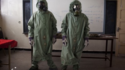 متطوعون يرتدون الملابس الواقية من الكيماويات في حلب - أ ف ب