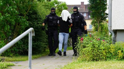 الشرطة الألمانية تقتاد أحد المتهمين بتهريب اللاجئين في عملية أمنية سابقة - DPA