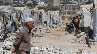 لاجئ سوري أمام خيام مهدمة في عكار شمالي لبنان - 9 آب 2019 (AFP)