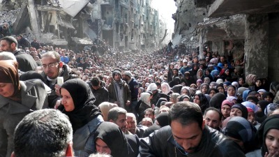 الآلاف من الفلسطينيين في مخيم اليرموك بريف دمشق ينتظرون وسط الدمار المساعدات الإنسانية 3 كانون الثاني 2014 (Getty)