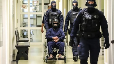 المتهم السوري وهو جالس على كرسي بحراسة أربعة ضباط في ألمانيا (بيلد)