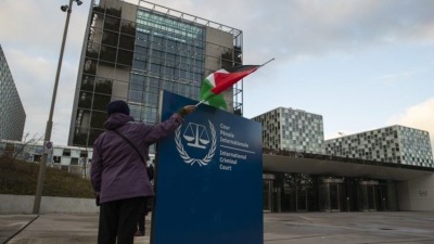 رجل يحمل العلم الفلسطيني أمام محكمة العدل الدولية في لاهاي، هولندا (الإنترنت)