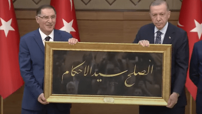 أردوغان يرفع هدية مع شريف مالكوتش رئيس ديوان المظالم خلال مؤتمر دولي نظمته مؤسسة أمناء المظالم في تركيا - الأناضول