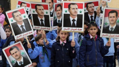 أطفال سوريون يحملون صور بشار الأسد خلال مسيرة لدعم النظام في مدينة حلب - 17 تشرين الثاني 2014 (AFP)