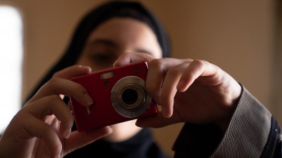 اللاجئة السورية آية وهي تستخدم كاميرتها لتوثق جوانب من حياتها في لبنان