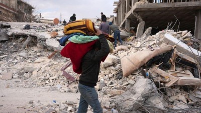 شخص يحمل بطانيات في شمال غربي سوريا (مجموعة العمل)