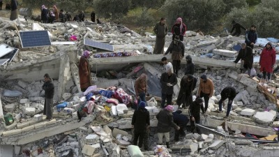 سوريون يفتشون تحت الأنقاض المنهار عن ناجين في مدينة حارم، ريف إدلب/ 6 شباط/فبراير 2023 (AP)