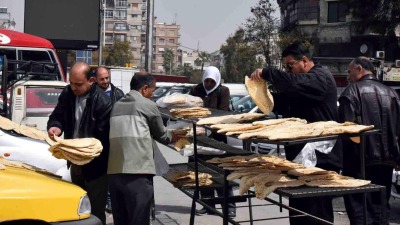 تنشيف الخبز على الأسطح المعدنية أمام فرن الفحامة في دمشق – 25 آذار 2021 (صحيفة تشرين)