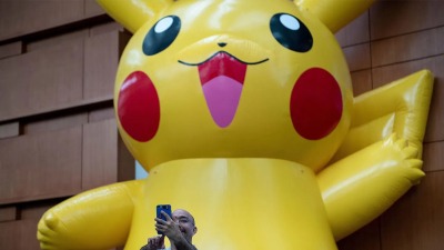 رجل يلتقط صورة سيلفي مع شخصية بيكاتشو في أول يوم من بطولة بوكيمون في مركز المؤتمرات بواشنطن- التاريخ 16 آب 2019