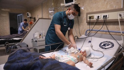 أحد الأطباء في إدلب وهو يعالج رضيعاً خرج من بين الأنقاض بعد الزلزال