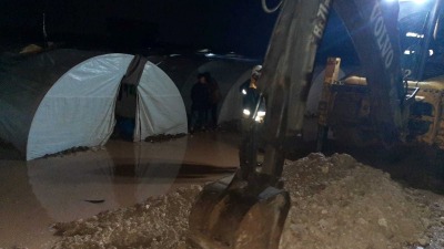 فرق الدفاع المدني تعمل على فتح قنوات لتصريف مياه الأمطار في مخيمات ريف حلب الشمالي، 17 آذار 2023 (الدفاع المدني السوري)