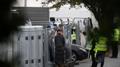 أشخاص داخل مركز "مانستون" لاستقبال اللاجئين والمهاجرين في بريطانيا (رويترز)