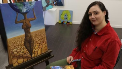 الفنانة النمساوية المكسيكية إنانا كوسي مع لوحتها: "غايا"