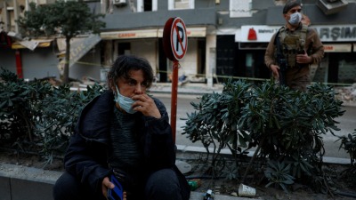 سيدة تركية تجلس أمام أنقاض منزلها المنهار بعد الزلزال المميت في أنطاكيا - هاتاي (رويترز)