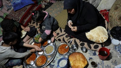 أم تفطر مع أطفالها في خيمة بمدينة جنديرس شمالي سوريا ـ رويترز 