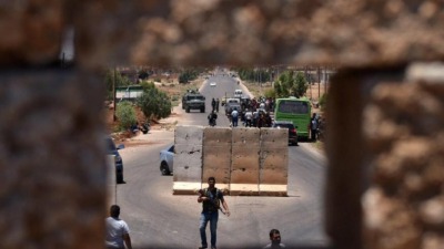 عناصر من قوات النظام يفتشون مدنيين على حاجز في درعا (أرشيفية/AFP)