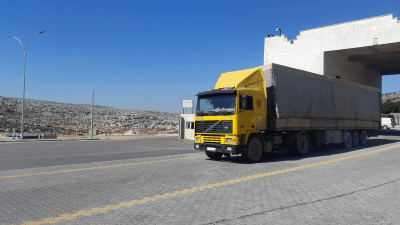 شاحنة تحمل مساعدات أممية تدخل من معبر باب الهوى إلى الشمال السوري - الجزيرة