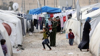 نساء سوريات وأطفال في مخيم قرب الحدود السورية التركية - رويترز