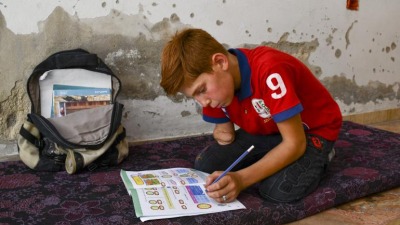 الطفل السوري عبد الرحمن وهو يكتب وظائفه